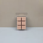 Pack of pink wax melts in clear packaging on a gray background