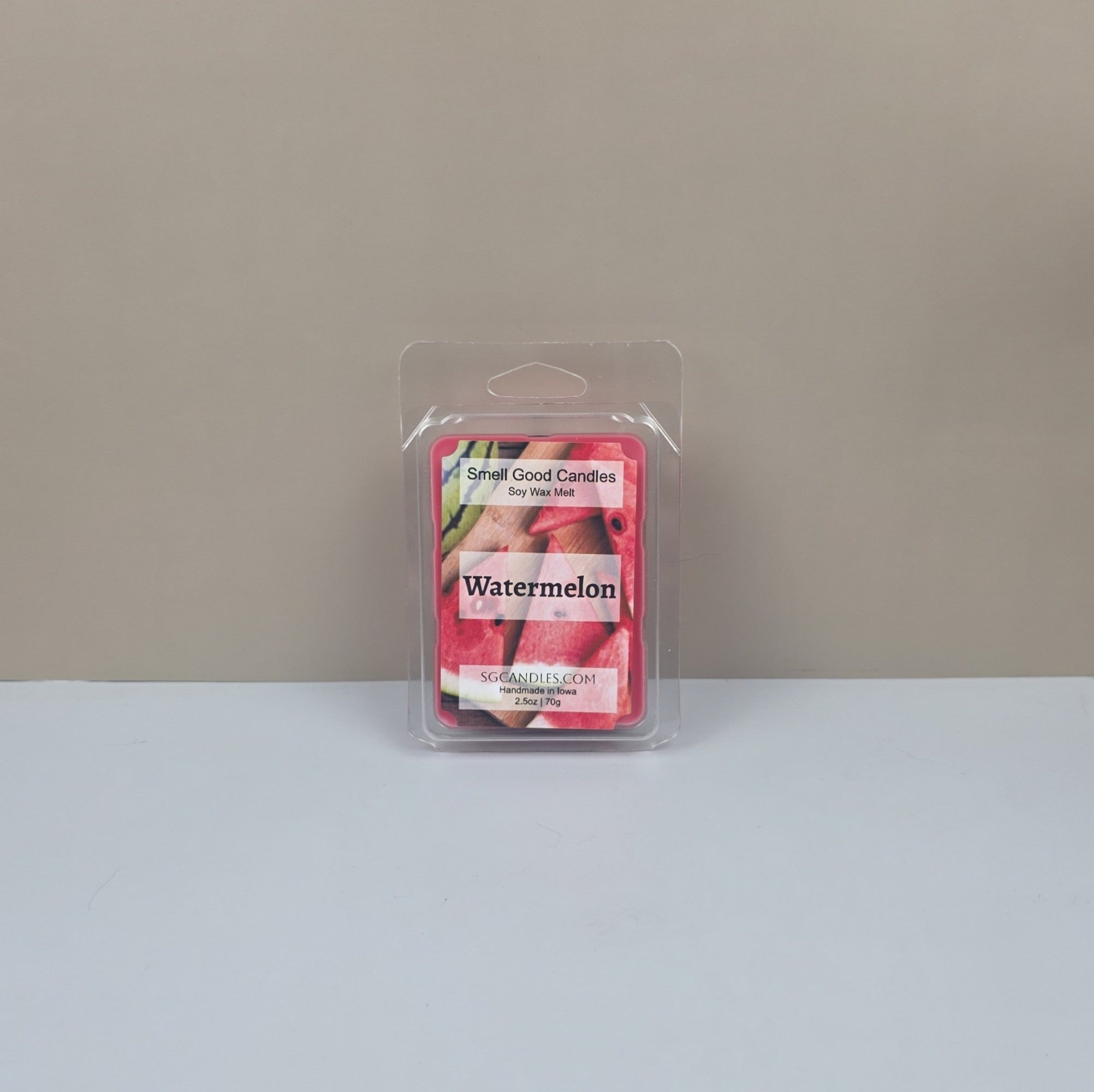 Packaged watermelon-scented candle on a neutral background