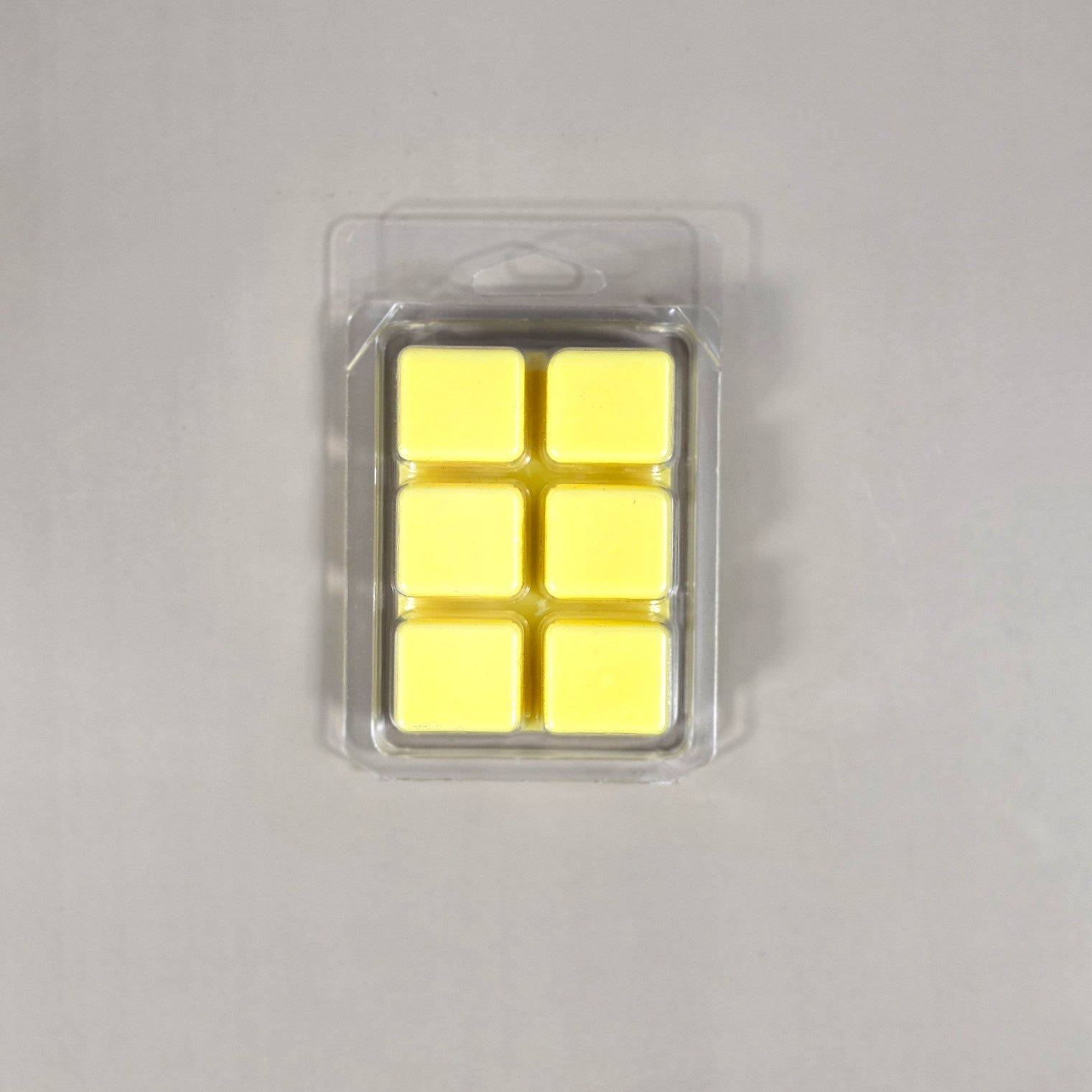 Clear 6-cavity clamshell packaging showcasing cream-colored, hand-poured soy wax melt cubes for home fragrance.