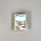 Labeled Wood Sage & Sea Salt soy wax melt in a 2.5oz clamshell featuring a peaceful coastal scene with driftwood and ocean waves.